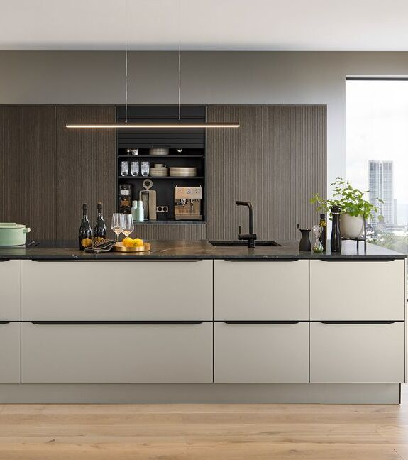 Hidden handle kitchen showing the integrated profile grip on the door edge with a completely flat front face