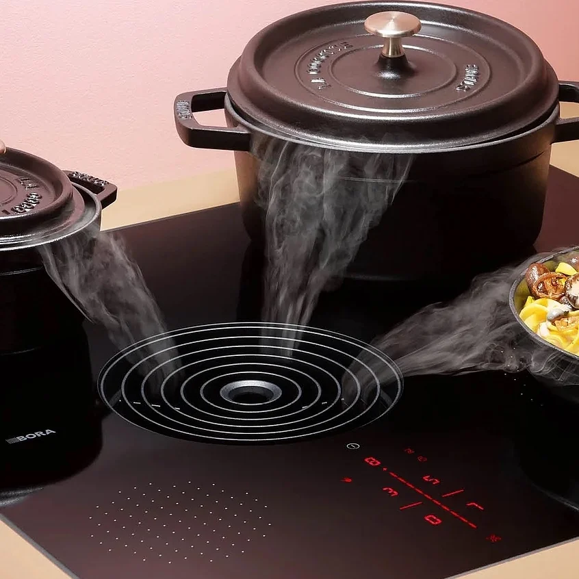 Vented induction hob with integrated downdraft extraction built into the worktop between the cooking zones