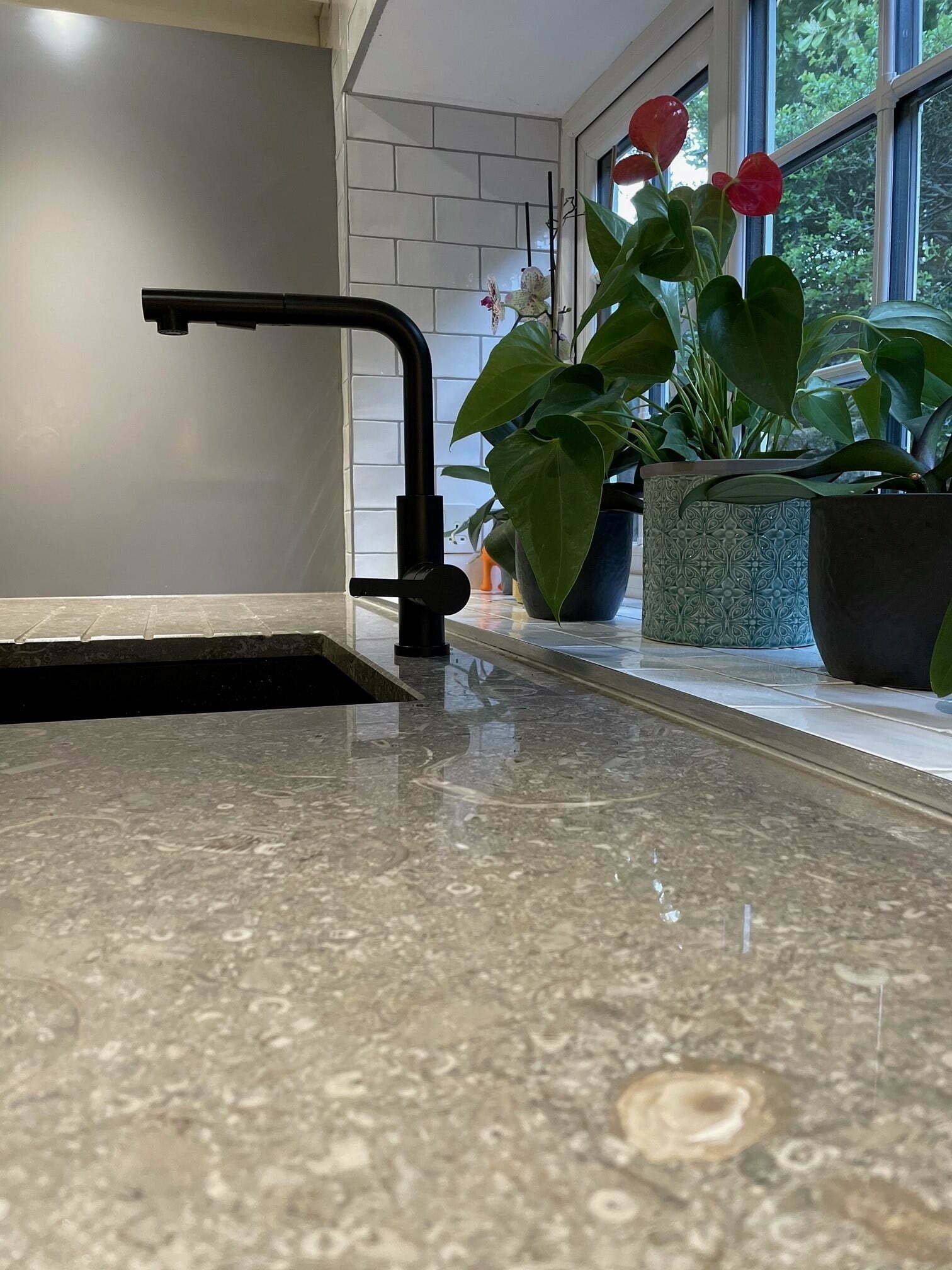 Limestone kitchen worktop showing the natural stone surface detail with the warm cream tones and characteristic fine grain of limestone installed in a traditional kitchen setting
