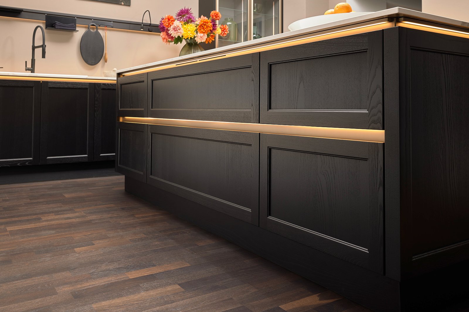 Nobilia Handless Shaker kitchen in soft matt black showing the Shaker frame profile with no visible surface hardware on base units and tall housing