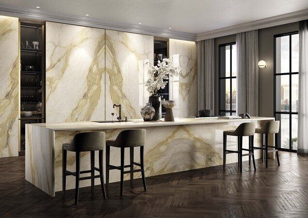 Book-matched porcelain worktop on a kitchen island showing the mirrored veining pattern across the central join with symmetrical marble-effect veining creating a dramatic visual statement