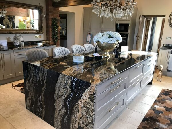 Dark granite worktop showing a bold black and gold mineral pattern with dramatic veining across the polished surface