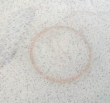 Quartz worktop showing heat damage marks from direct hot pan contact illustrating the permanent discolouration and dull patches that result from placing hot cookware directly on the quartz surface without trivets or heat protection