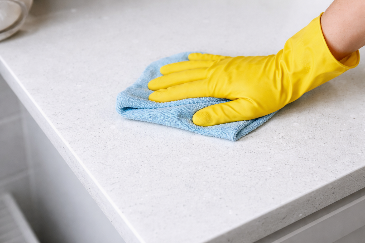 Quartz worktop being cleaned with a soft cloth and mild detergent demonstrating the simple daily maintenance routine for quartz kitchen worktops that requires no specialist products sealing or professional periodic treatment