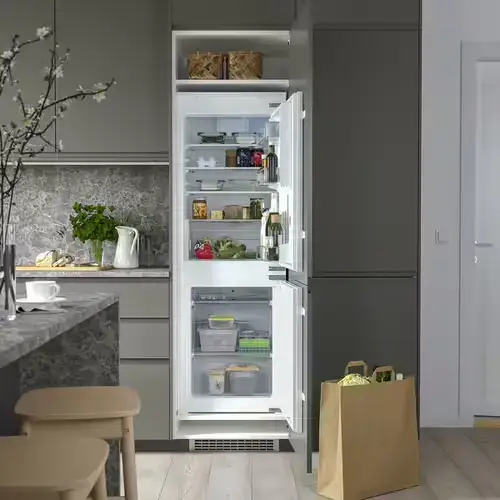177cm high integrated fridge freezer installed in a tall kitchen housing unit showing the standard height built-in fridge freezer behind a full-height furniture door in a contemporary fitted kitchen