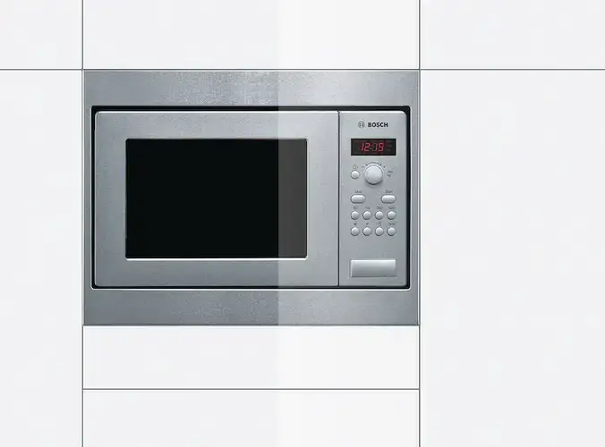 Standard 380mm high built-in microwave in a kitchen housing unit showing the compact niche height and the clean front panel design of a built-in microwave at approximately 380mm tall and 600mm wide fitted into a tall housing column or wall unit