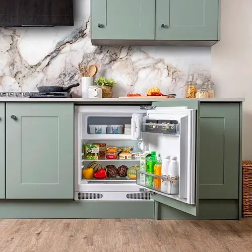 Built-under integrated fridge freezer installed below a kitchen worktop in a standard undercounter position showing the smaller format of a built-under refrigerator compared to a full-height tall integrated fridge freezer in a kitchen renovation