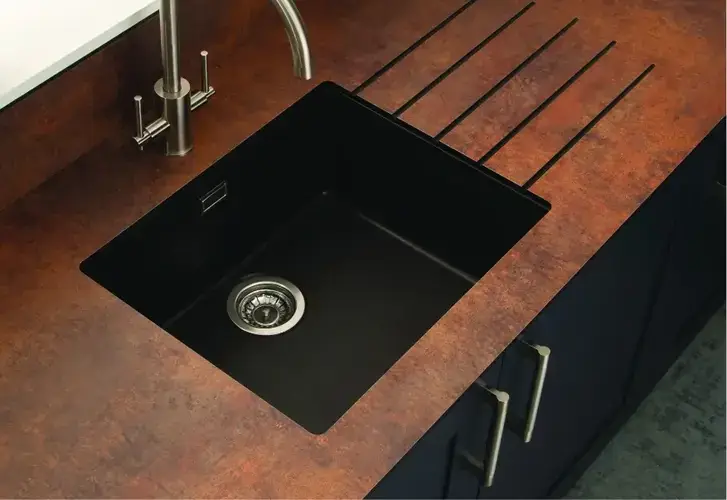 HPL worktop edge detail showing the high-pressure laminate surface layer and the core substrate in a contemporary kitchen setting with a clean straight edge profile and realistic pattern matching at the front face of the worktop