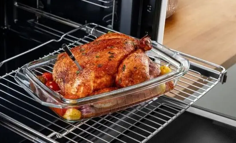 Meat probe in a built-in oven showing the temperature sensing probe inserted into a roasting joint connected to the oven control system which displays the internal food temperature and automatically adjusts or stops cooking when the target temperature is reached