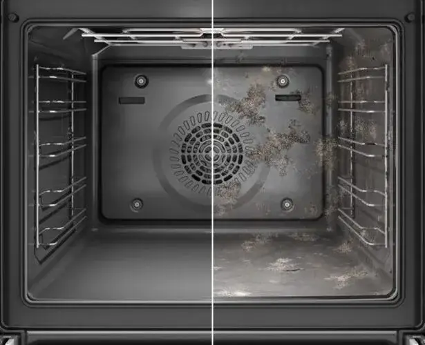 Pyrolytic self-cleaning oven interior showing the high-temperature cleaning cycle in action with the oven cavity at elevated temperature burning food residue to fine ash that wipes away when cool