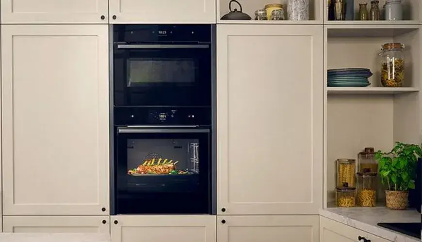 Built-in combination microwave and single oven stacked in a tall housing unit showing the compact combi microwave at 450mm niche height positioned above or below a full-size 60cm single oven in an appliance tower configuration
