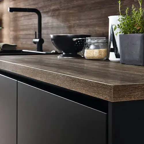 German kitchen manufacturer laminate worktops from Nobilia showing the coordinated worktop and door finish combination with the stone-effect laminate surface complementing the handleless kitchen door design in a contemporary German kitchen installation