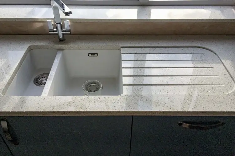 Quartz worktop with recessed drainer showing the shallow flat depression in the quartz surface beside the sink creating a clean contemporary drainer zone with no groove lines and a smooth flat surface slightly lower than the surrounding worktop