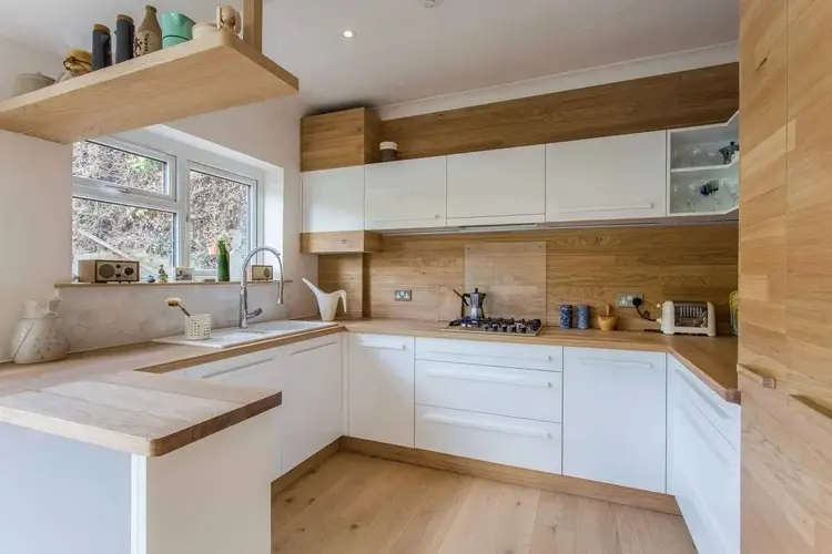 Premium solid oak worktop installed on a kitchen island showing the full-stave construction, warm honey tone, and natural grain pattern of well-oiled hardwood in a contemporary kitchen