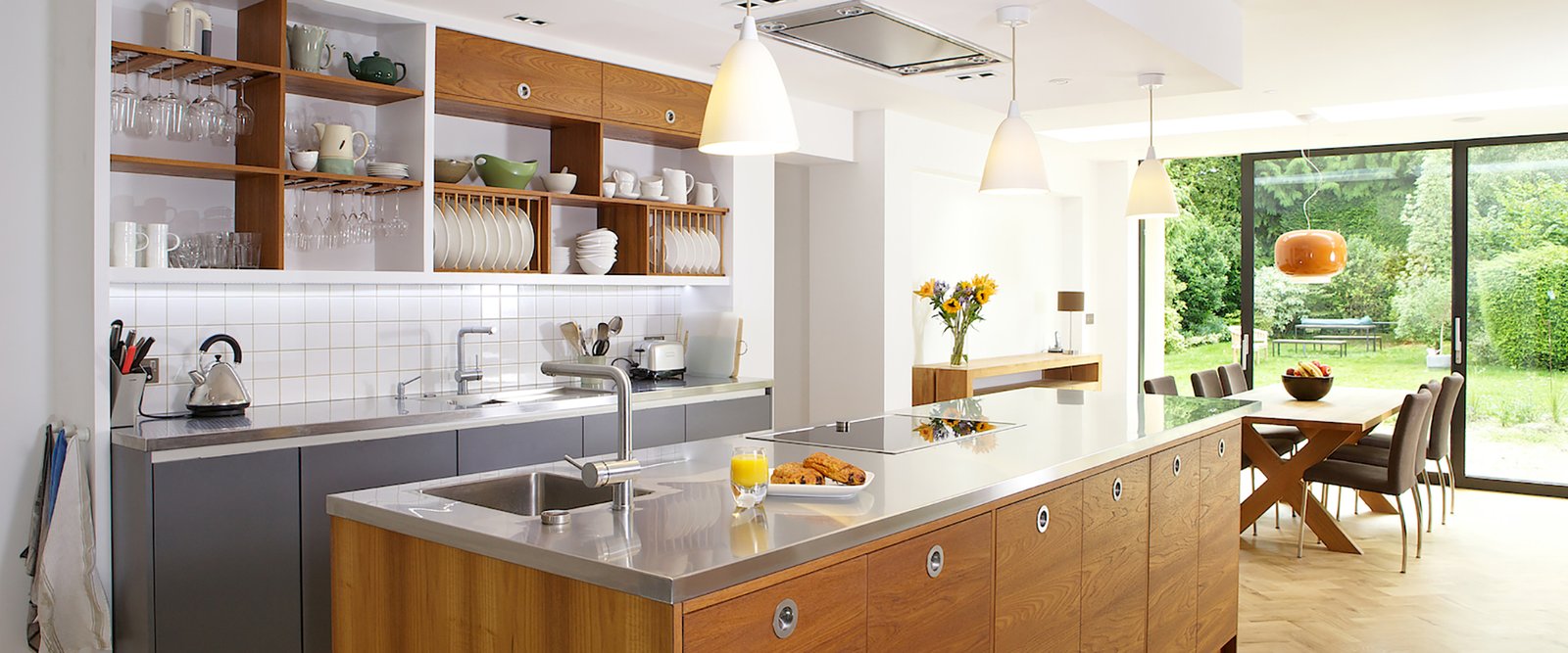 Premium stainless steel kitchen worktop installation showing the full-length brushed surface with integrated drainer grooves and welded sink bowl with the continuous professional finish that distinguishes fabricated steel from any other worktop material